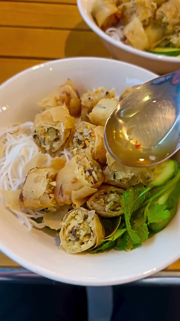 Crisp chả giò spring rolls on vermicelli with herbs and dipping sauce